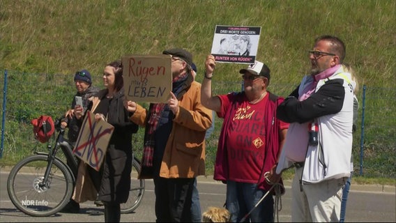 Menschen protestieren mit Schildern gegen eine geplantes LNG-Terminal auf Rügen. © Screenshot 