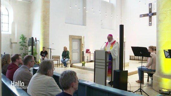 Ein Bischof steht an einem Rednerpult und spricht zu den Teilnehmenden. © Screenshot 