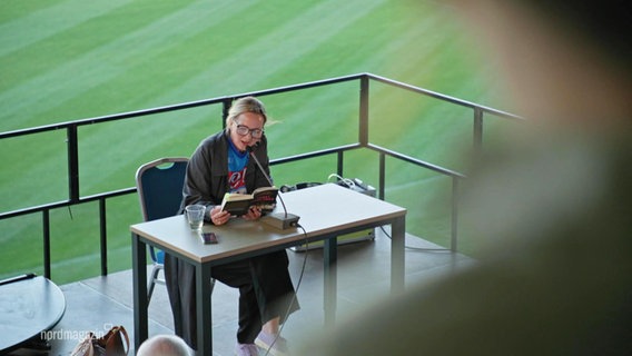Eine Lesung auf den Tribünen eines Fußballstadions. © Screenshot 