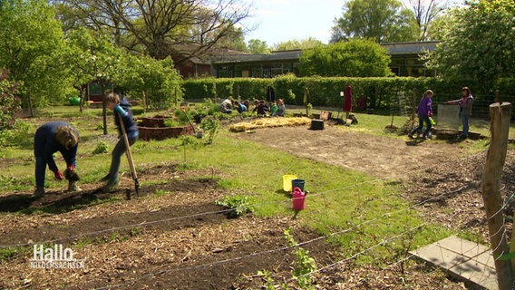 Blick in einen Garten in dem mehrere Kinder arbeiten. © Screenshot 