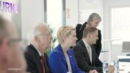Mecklenburg-Vorpommerns Ministerpräsidentin Manuela Schwesig sitzt in einem Besprechungsraum mit mehreren Personen an einem Tisch. © Screenshot 