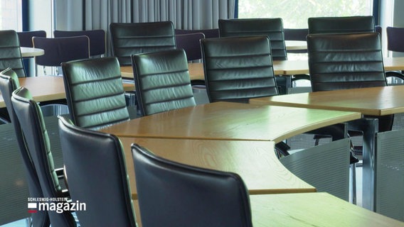 Mehrere Stühle und Tische eines Sitzungssaales. © Screenshot 