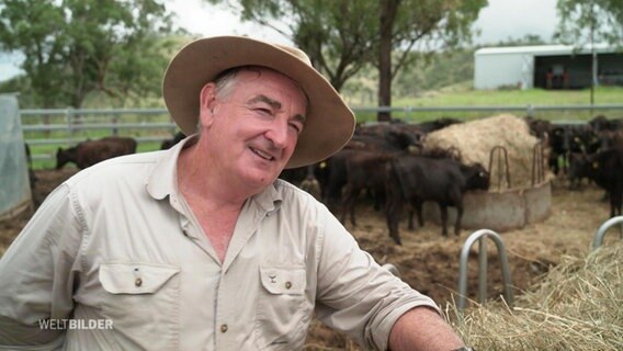 Farmer Michael Dempsey lehnt sich vor seinem Rindergehege an einen Heuballen. © Screenshot 