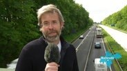 Reporter Matthias Schuch steht auf einer Autobahnbrücke. © Screenshot 