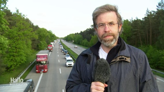 Reporter Mathias Schuch berichtet live von einer Brücke über der Autobahn. © Screenshot 