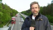 Reporter Mathias Schuch berichtet live von einer Brücke über der Autobahn. © Screenshot 