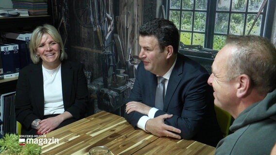 Bundesarbeitsminister Hubertus Heil an einem Tisch mit Malermeisterin Jessica Hansen und ihren Mitarbeitenden. © Screenshot 
