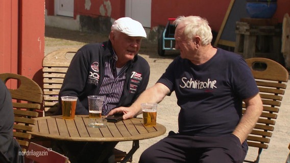 Zwei ältere Herren sitzen am Vatertag zusammen und trinken ein Bier. © Screenshot 