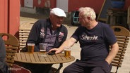 Zwei ältere Herren sitzen am Vatertag zusammen und trinken ein Bier. © Screenshot 