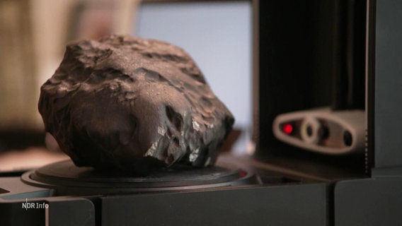 Ein etwa faustgroßer Meteorit wird gescannt und untersucht. © Screenshot 