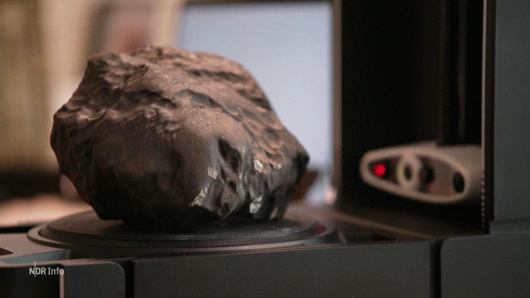 Ein etwa faustgroßer Meteorit wird gescannt und untersucht.