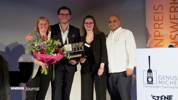 Vier Personen posieren für die Kamera bei der Verleihung des Restaurantpreises "Genuss-Michel." © Screenshot 