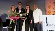 Vier Personen posieren für die Kamera bei der Verleihung des Restaurantpreises "Genuss-Michel." © Screenshot 