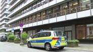 Razzia gegen "Letzte Generation": Ein Polizeiauto steht vor einem Gebäude in Hamburg. © TV Newskontor 