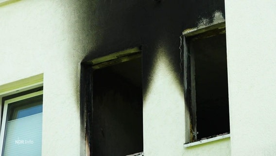Zwei kaputte Fenster und Ruß an der Außenwand eines Wohngebäudes. © Screenshot 