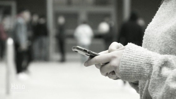Frau hält Handy in der Hand. © Screenshot 