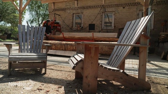 Auf einem Hinterhof stehen zwei handgefertigte Gartenstühle aus Holz. © Screenshot 