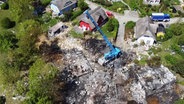 Blick aus der Luftperspektive auf eine größeres Trümmerfeld nach einer Explosion einer Gasleitung in einer Feriensiedlung. © Screenshot 
