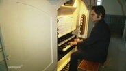 Ein Organist sitzt an einer Orgel und spielt konzentriert. © Screenshot 