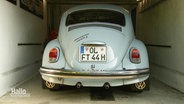 Ein blauer Oldtimer-Käfer steht in einer Garage. © Screenshot 