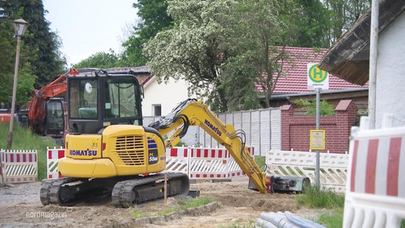 Ein Bagger steht auf einer Baustelle vor einer Bushaltestelle. © Screenshot 