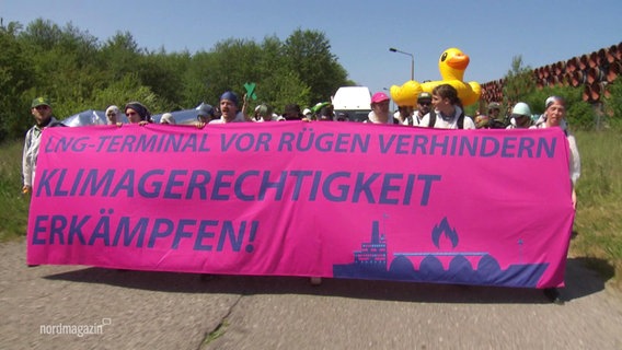 Protestierende halten ein Banner mit der Aufschrift: "LNG-Terminal von Rügen verhindern - Klimagerechtigkeit Erkämpfen!" © Screenshot 