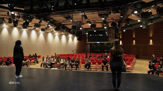 Zwei Schülerinnen bei einer Probe auf einer Theaterbühne. © Screenshot 