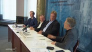 Ein Podium mit vier Männern bei der Landespressekonferenz. © Screenshot 