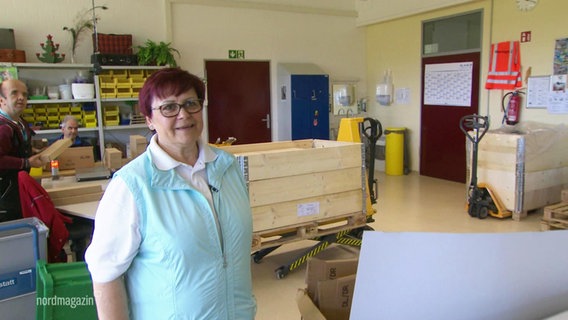 Manuela Stebnitz lächelnd bei der Arbeit in den Stralsunder Werkstätten. © Screenshot 