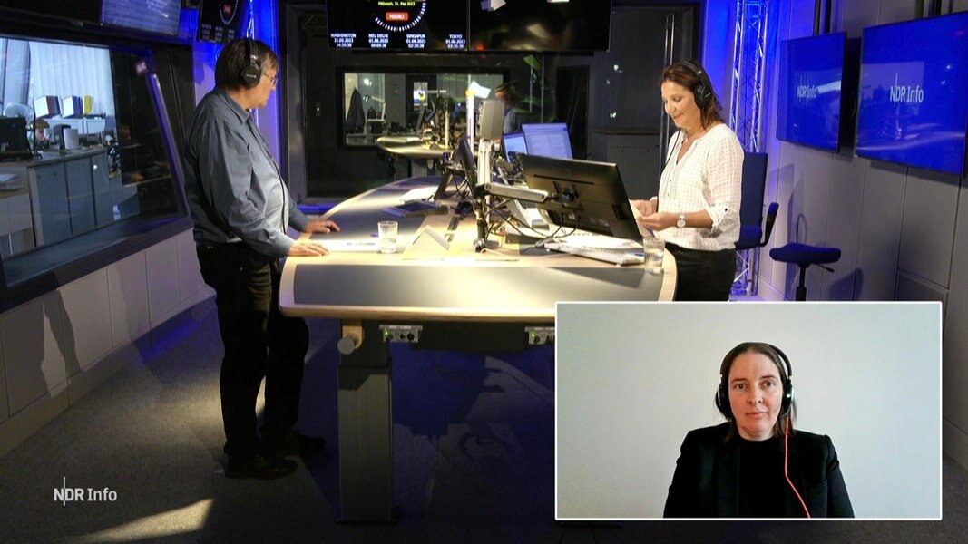 Janine Albrecht moderiert die NDR Info Redezeit. Sie steht mit einem Gast im Studio. Eine Gesprächspartnerin ist zugeschaltet.