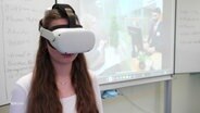 Eine Schülerin trägt eine Brille, die virtuelle Realität simulieren kann. © Screenshot 