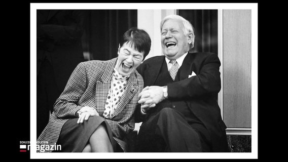 Ein Schwarz-Weiß-Bild zeigt Loki und Helmut Schmidt lachend. © Screenshot 
