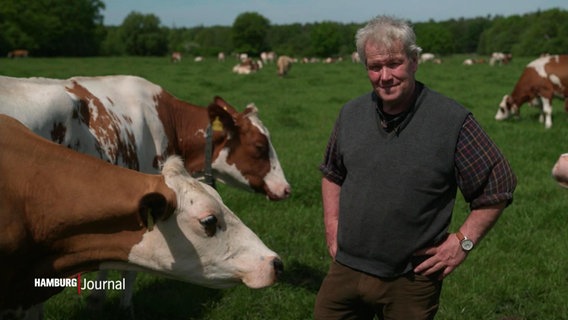 Milchbauer Jaacks steht neben seinen Kühen auf einer Weide. © Screenshot 