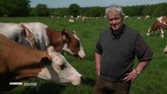 Milchbauer Jaacks steht neben seinen Kühen auf einer Weide. © Screenshot 