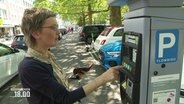 Eine Frau kauft eine Parkticket an einem Automaten. © Screenshot 