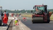 Baumaschine asphaltiert Teer auf der Landebahn des Hamburger Flughafens. © Screenshot 