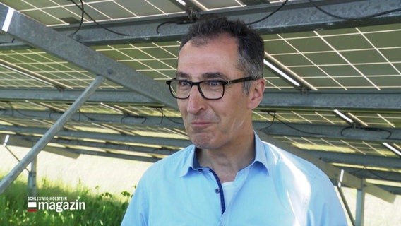 Bundeslandwirtschaftsminister Cem Özdemir (Grüne) steht bei einem Interview unter einer Solaranlage. © Screenshot 