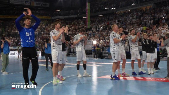 Handballer des THW Kiel stehen nach einem gewonnenen Spiel klatschend vor der Zuschauertribüne. © Screenshot 