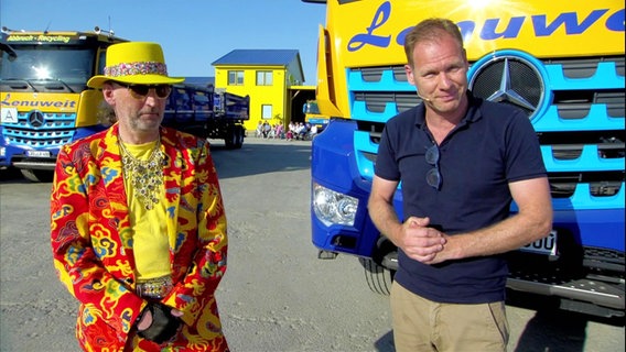 Moderator Thilo Tautz steht zusammen mit Abbruchunternehmer Roberto Lenuweit vor einem Lastkraftwagen auf einem Platz. © Screenshot 