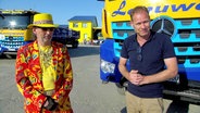 Moderator Thilo Tautz steht zusammen mit Abbruchunternehmer Roberto Lenuweit vor einem Lastkraftwagen auf einem Platz. © Screenshot 