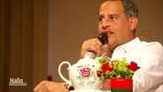 Moritz Bleibtreu sitzt vor einer Kanne Tee und spricht in ein Mikrofon. © Screenshot 