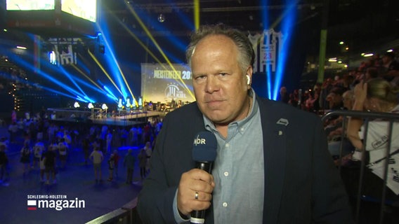 Ein NDR Reporter steht in der Handball-Arena in Kiel © Screenshot 