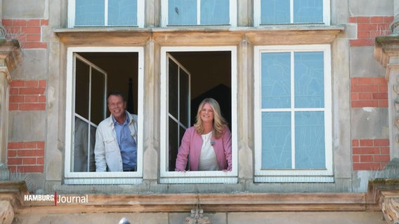 Nicole Steins und Ulf Ansorge stehen im Fenster des Harburger Rathauses. © Screenshot 