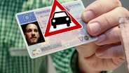 Ein Mann hält seinen Führerschein in die Kamera. (extra 3 vom 27.07.2023 im Ersten) © NDR 