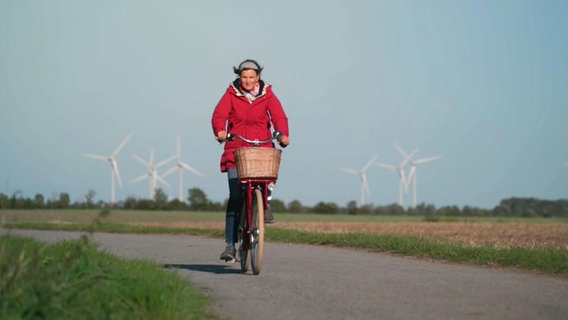 Heike Götz auf dem Fahrrad, im Hintergrund Windräder © Screenshot 