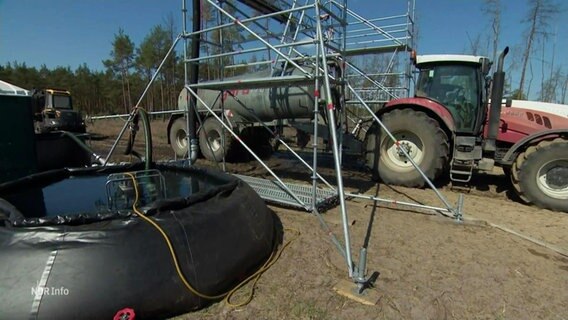 Ein Traktor mit Güllefass wird mit Wasser für Löscharbeiten betankt. © Screenshot 