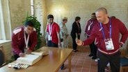 Die quatarische Special-Olympics Delegation trägt sich in das Gästebuch der Stadt Schleswig ein. © Screenshot 