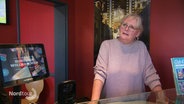 Eine Frau steht an der Theke einer Bar in einem Kino. © Screenshot 