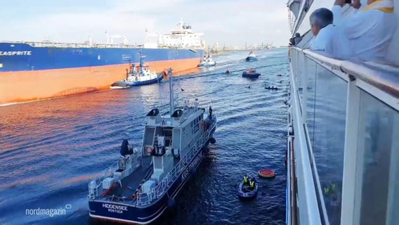 Mehrere Klimaaktivistinnen und -aktivisten haben mit Beibooten an einem Kreuzfahrtschiff festgemacht. © Screenshot 