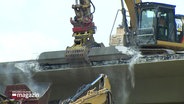 Ein Abrissbagger zerlegt eine Brücke über der A7. © Screenshot 